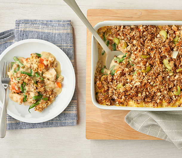 An image of prepared Country Chicken Casserole showing onion, celery, Swanson® Chicken Broth, Pepperidge Farm® Herb Seasoned Stuffing, Campbell's® Condensed Cream of Chicken Soup, green beans, carrots and cooked chicken or turkey.